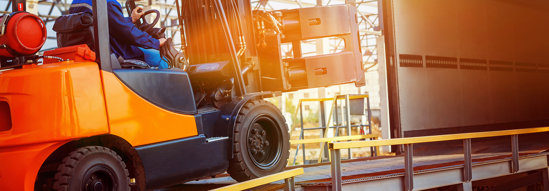 Man using heavy machinery to load a truck with supplies | Virginia Defective Machinery Attorneys