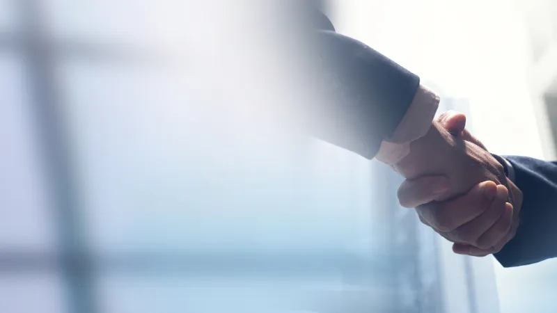 Businessmen making handshake with partner,