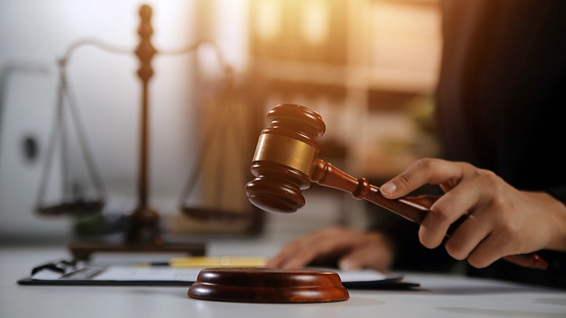 A judge, holding a wooden gavel.